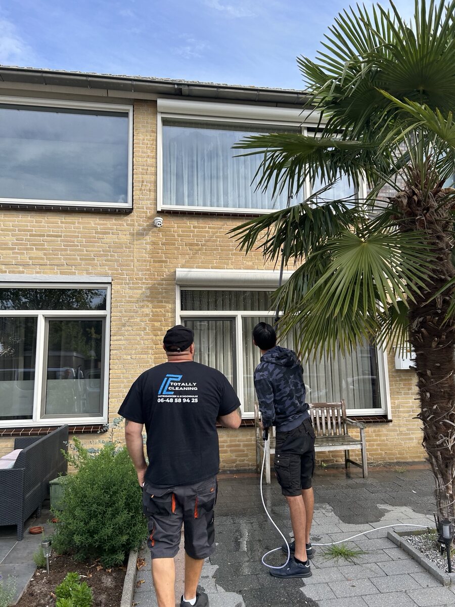 Medewerkers van Totally Cleaning tijdens glasbewassing bij een woning