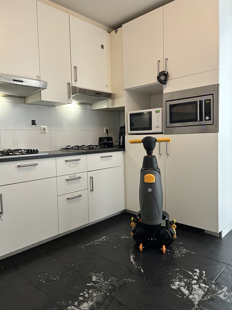 Vloerreinigingsmachine tijdens schoonmaak in een keuken